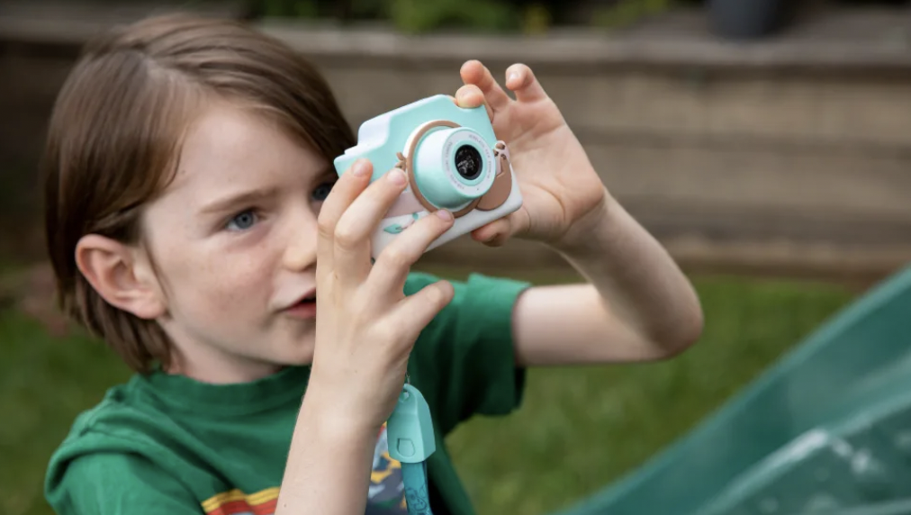 A child holds a Kidamento Model K kids' camera.